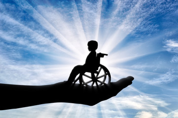 Obraz na płótnie Canvas Disabled child in a wheelchair in a man's hand