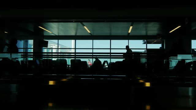 Silhouettes of passengers at the airport. A hurry on a plane or sitting in anticipation of landing