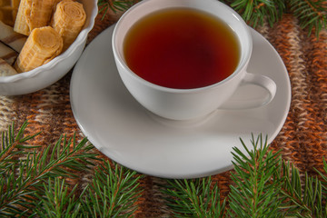 The Christmas tea. A Cup of tea. Christmas decor. In warm tones. Knitted background. Studio light.