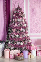 New Year tree decorated in pink toys. Christmas background with presents in room interior