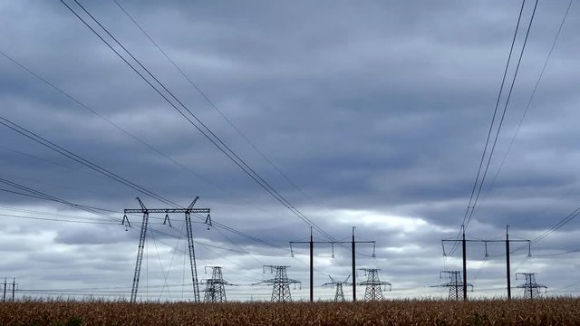 Pylons of high voltage powerline under running clouds time lapse footage