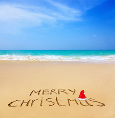 Merry Christmas written on a sandy beach