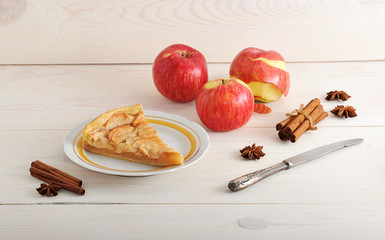 slice  of apple pie and ingredients - apples and cinnamon
