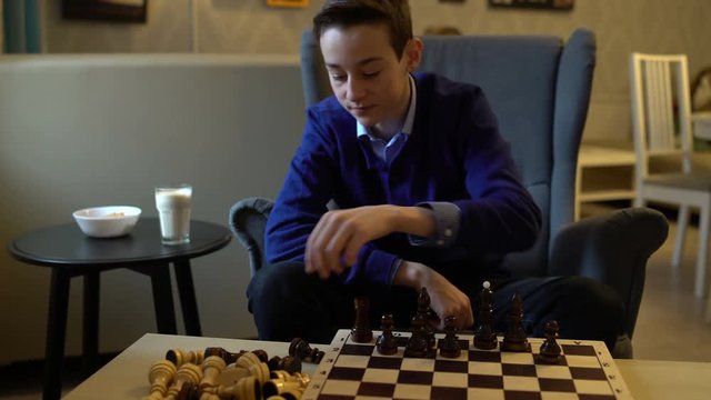 Teen puts the chess pieces on the board