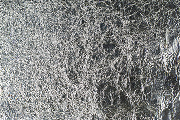 sheet of silver leaf background with shiny crumpled uneven surfa