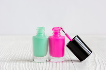 open bottles of nail polish on wooden background close up