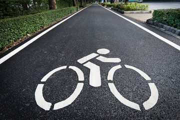 Obraz premium Close up shot of bicycle lane symbol on long asphalt road. Traffic sign