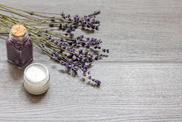 cosmetic creams with lavender flowers on black wooden table