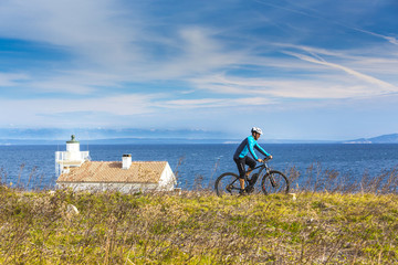 Obraz premium Mountainbiker mit Ebike am Meer