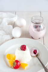 Ice cream with berries in white plate, yogurt and egg