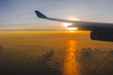Airplane's wing against golden sunlight in early morning