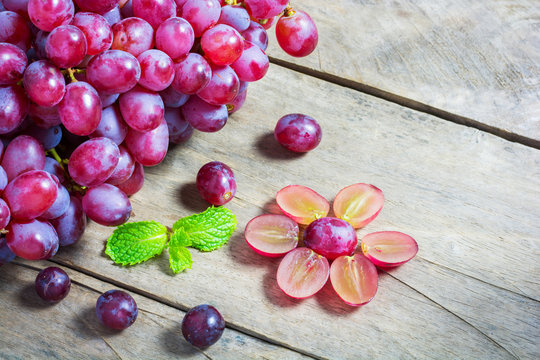 Grape, Bunch of fresh red grapes with green mint leaf on wooden