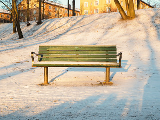 Green bench in the park with snow