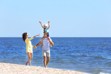 Family concept. Parents with daughter walking on the beach