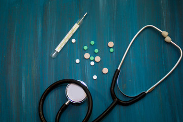 medical background: a stethoscope, thermometer, pills