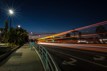 Fototapeta na wymiar Predawn city lights and streaking cars along Main Street sidewalk.