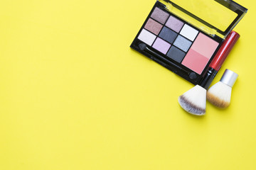 Set of colorful cosmetics on yellow background