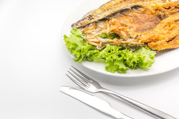 Fried snapper topped serve with sweet fish sauce, fresh Lettuce and Cutlery Set, Isolate on a white background, Top view with copy space and text