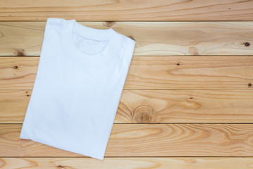 White T-Shirt on wood teble background , Top view