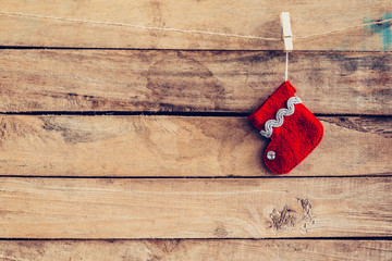 red sock for Santa gifts hanging over rustic wooden background.