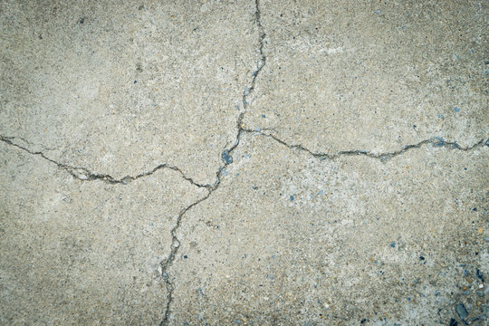 Concrete Floor Is Cracked All The Way. Broken Mark On A Concrete Floor For Texture And Background.