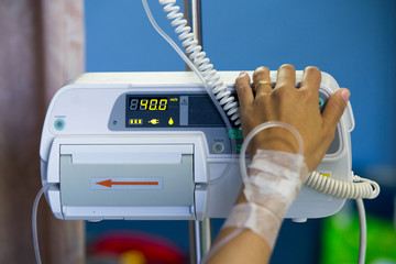 Infusion pump feeding saline drip into patients arm