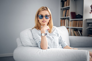 Portrait of blonde female in blue hipster sunglasses.