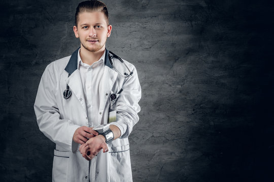 Portrait of young medical health doctor on grey background.