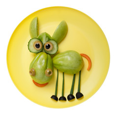 Amusing donkey made of green tomato on plate