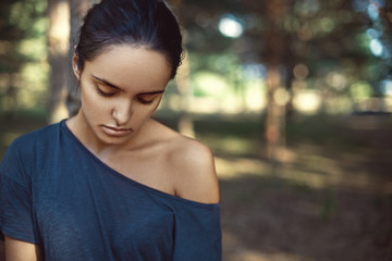Beauty portrait of a pretty brunette girl in summer forest.