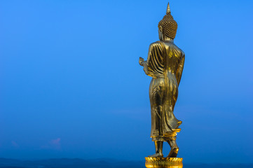 Buddha standing on a mountain at twilight time at Wat Phra That