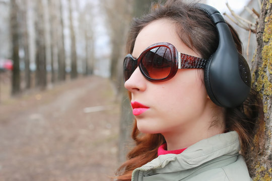 woman with headphones in park autumn