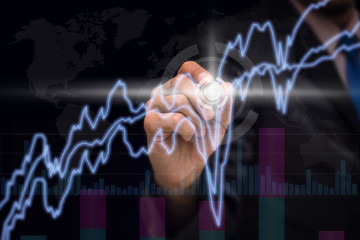 Businessman hand writing stock market charts and graph informati