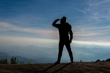 silhouette of a man who looking over the mountains landscape