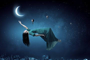 Obraz na płótnie Canvas Woman levitating in sky . Mixed media