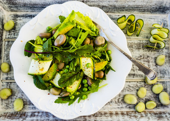 Delicious green salad with zucchini and beans with sweet peas. Healthy vegetarian food.