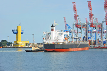 Tugboat assisting bulk cargo ship