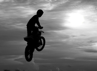 Motocross rider jumping happily. While floating in the sky like
