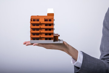 apartment building miniature model on woman hand