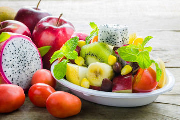 Diet-Fresh tasty mix fruit salad in the bowl on the wooden table
