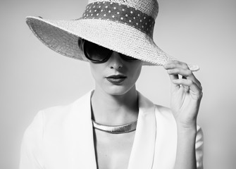 Black and white fashion portrait of female wearing hat. 