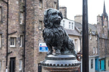 The statue of Greyfriars Bobby, a famous Terrier, in front of the Greyfriars cemetery on the George IV Bridge in Edinburgh, Scotland, UK