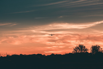 Silhouette of an Airplane in front of an Orange Sky sunset. 