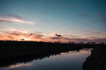 Silhouette of a Passenger Airplane at the Sunset is Landing in the Airport.