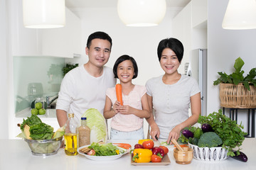 Naklejka premium Happy Asian family preparing food in the kitchen.