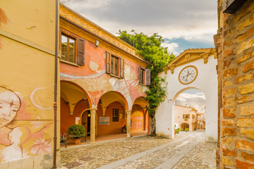 Fototapeta premium Painted walls on cobbled lane in medieval town