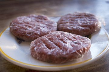 frozen beef hamburger wrapped in plastic film