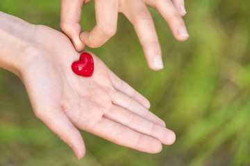Two small red heart on female hands