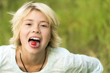 Small red heart lies in language of a young blonde girl. Toned