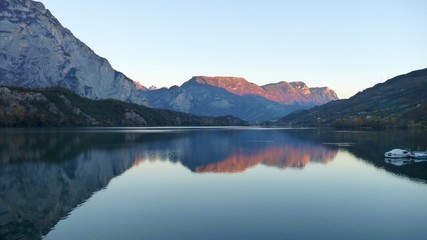 Fototapeta na wymiar reflection of mountains in water of lago Cavedine